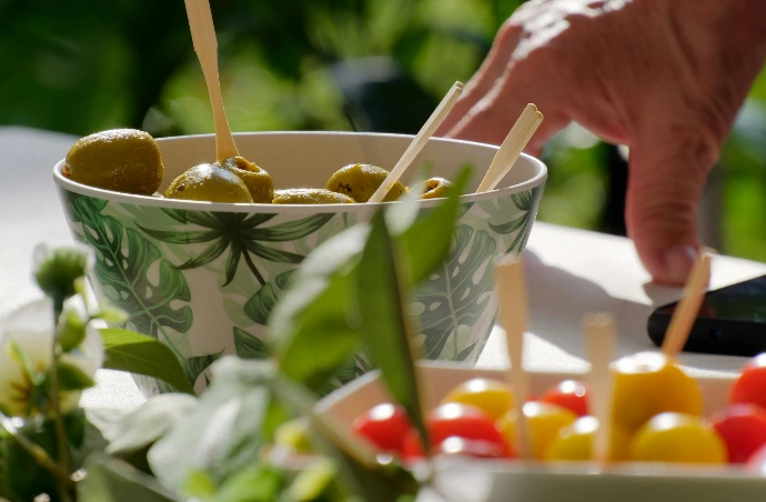 a bowl filled with olives and peppers on a table
